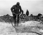 German POW using jack hammer to dig graves
